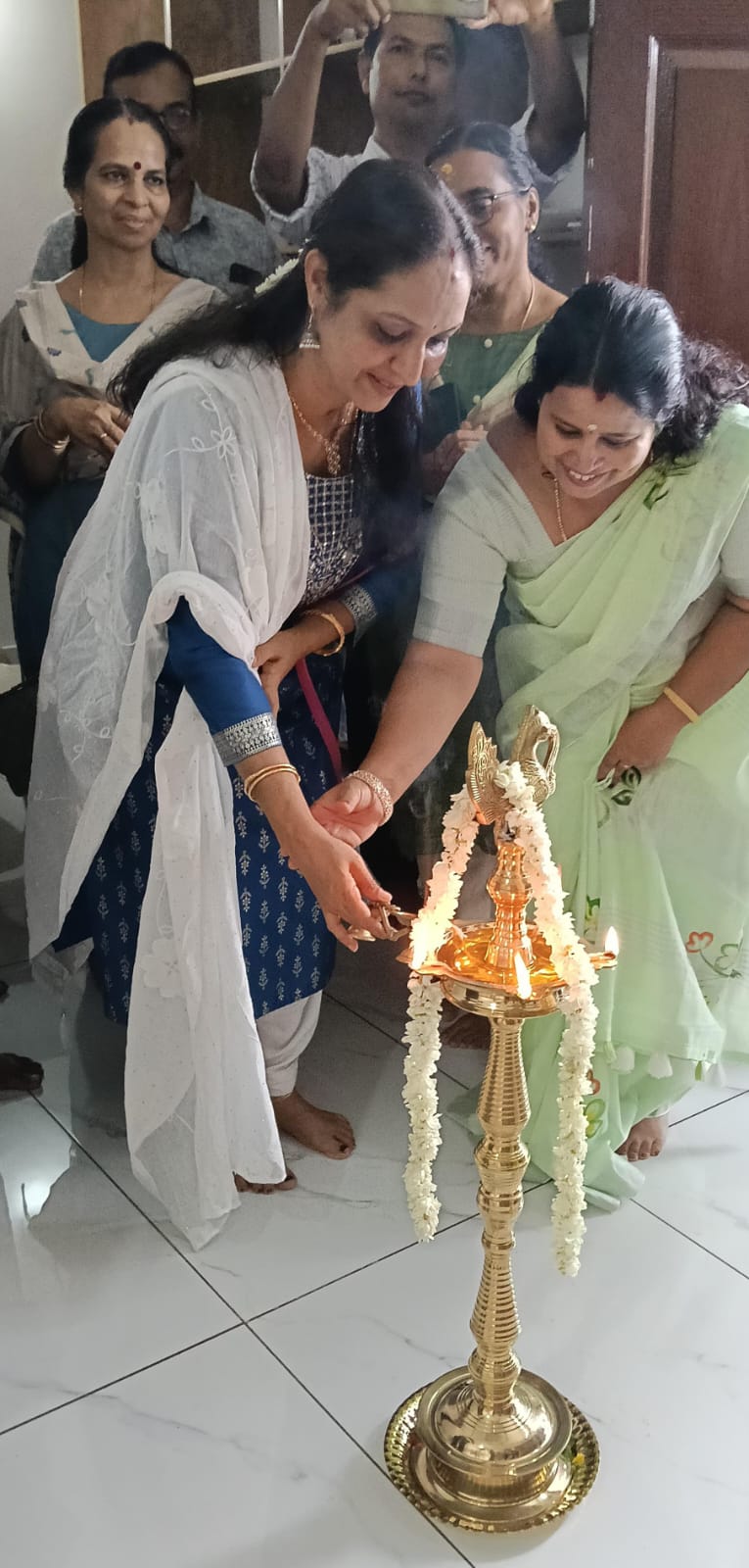 Family members lighting the ceremonial lamp together